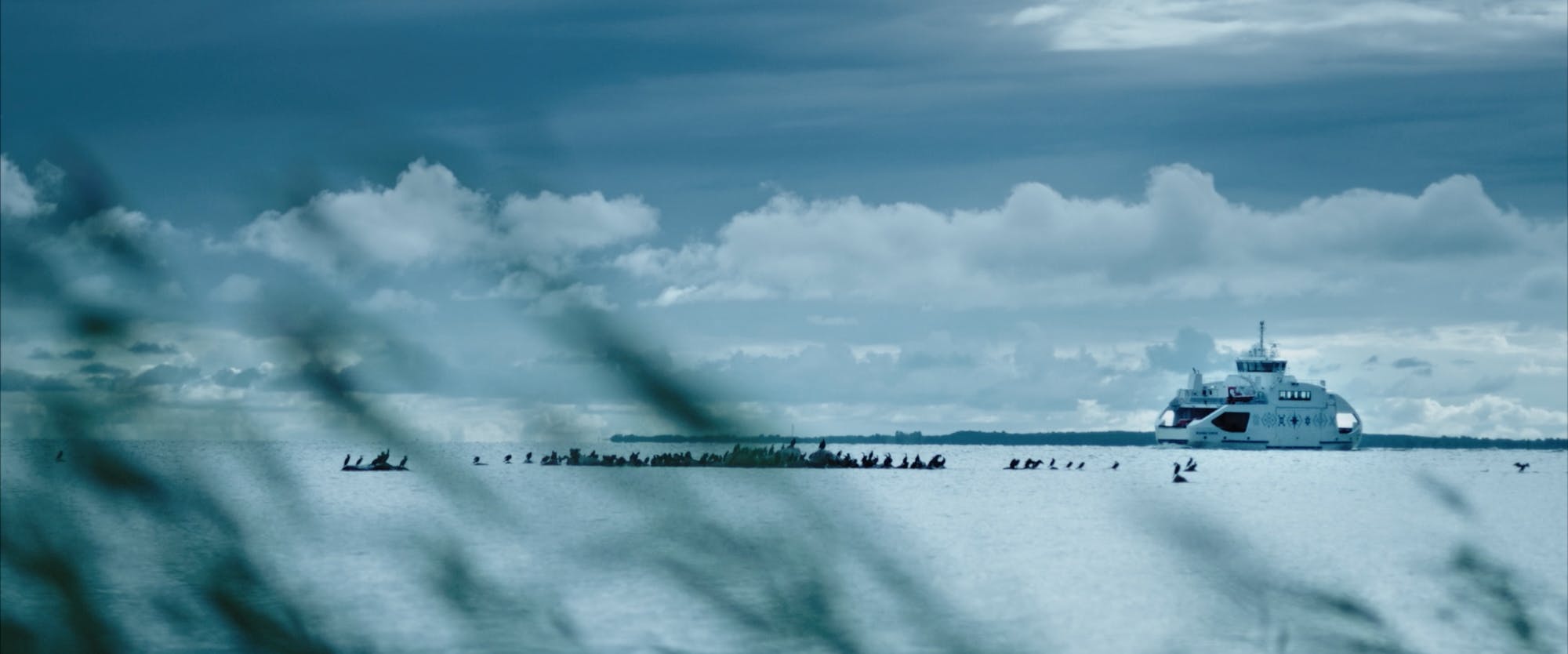 a ferry in the distance on the sea