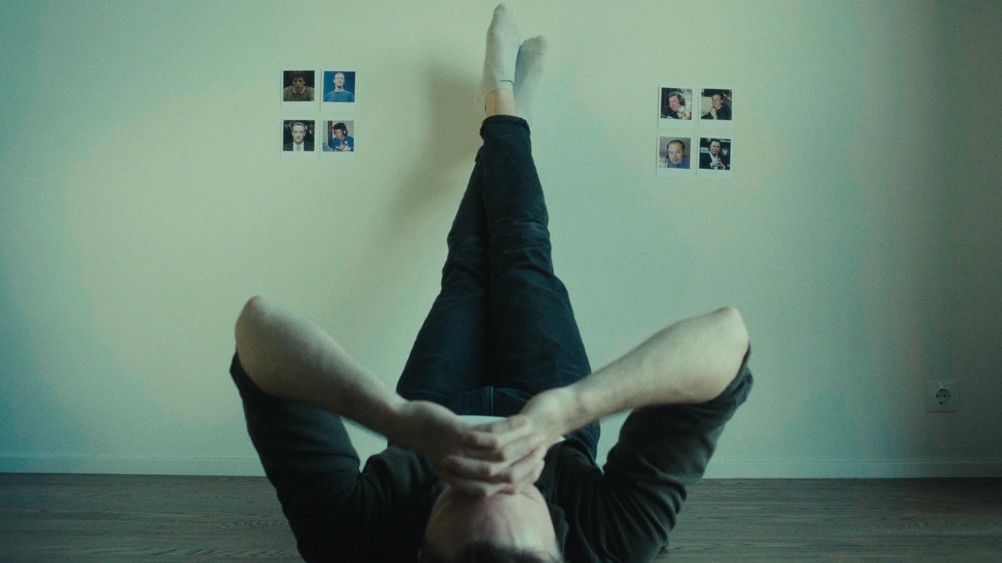 a man laying on the ground with legs on the wall